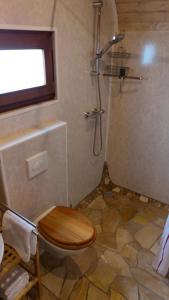 a bathroom with a wooden toilet and a shower at Pfälzer Zirkuswagen in Ranschbach