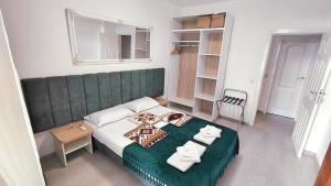 a bedroom with a green bed with towels on it at Luxury Lighthouse Golf Apartment in Balchik +8 photos