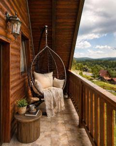 a hanging chair on a porch of a cabin at Iskrin breg in Ribnica