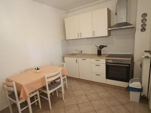 a kitchen with a table and a kitchen with white cabinets at Apartments Biba & Lucy in Ražanac