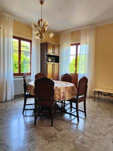 a dining room with a table and chairs and windows at Casa Farfalla in Cannobio