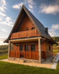 a large wooden cabin with a balcony on top at Iskrin breg in Ribnica +16 photos