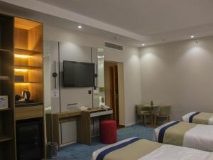 a hotel room with two beds and a flat screen tv at فندق برج جزيرة العرب in Medina +16 photos