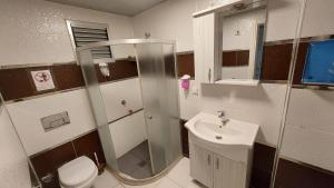 a bathroom with a shower and a toilet and a sink at Aksu Otel in Aliağa