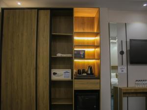 a room with a kitchen with a microwave and a television at فندق برج جزيرة العرب in Medina