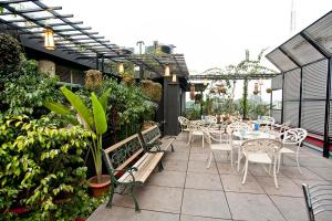 an outdoor patio with tables and chairs and plants at Well Park Residence in Chittagong