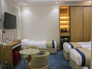 a hotel room with two beds and a tv at فندق برج جزيرة العرب in Medina