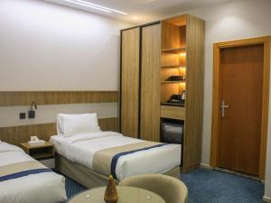 a hotel room with two beds and a table at فندق برج جزيرة العرب in Medina