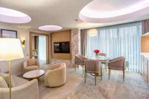 a living room with a table and chairs at Almaty Hotel in Almaty