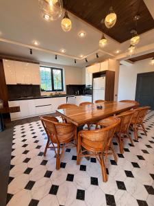 a large kitchen with a wooden table and chairs at Mountain Symphony Cottage Dilijan in Dilijan