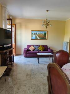 a living room with a purple couch and a tv at Casa Farfalla in Cannobio