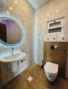a bathroom with a sink and a toilet at 7th Circle Suite in Umm Uthainah +26 photos