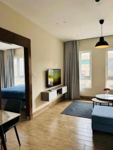 a living room with a bed and a tv at 7th Circle Suite in Umm Uthainah