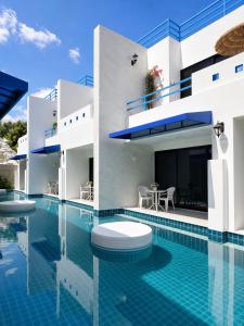 a villa with a swimming pool in front of a house at Monalisa Blue haven pool hotel in Pattaya South