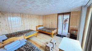 a room with two beds and a man standing in it at Blue Pearl - Khovsgol Lake in Khyaktil +13 photos