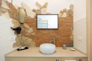 a bathroom with a mirror on a brick wall at Relais Villa Anna in Anacapri +15 photos