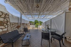 a room with a table and chairs and a stone wall at Relais Villa Anna in Anacapri