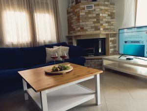 a living room with a couch and a table with wine glasses at Eva Maisonette in Iraklitsa