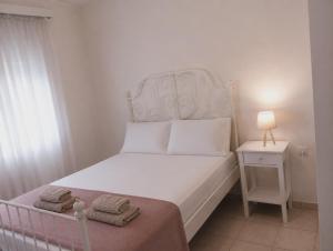 a small bedroom with a bed and a night stand at Eva Maisonette in Iraklitsa