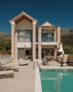 a house with a swimming pool in front of a house at Tomas Villas in Paleros