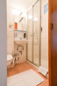 a bathroom with a shower and a sink at Strandhotel Pichler in Seeboden +68 photos
