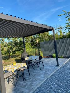 a patio with tables and chairs under a black canopy at Bobo Hegyi Kuckó in Sárvár