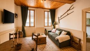 a living room with a couch and a table at Le Refuge de Mandrin, Elegance et tranquilité in Saint-Genix-sur-Guiers