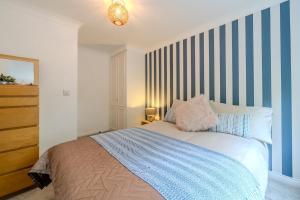 a bedroom with a bed with blue and white stripes at Ascot Racecourse Apartment in Ascot +7 photos
