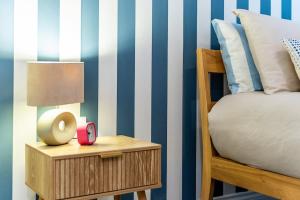 a bedroom with a bed and a table with a lamp at Ascot Racecourse Apartment in Ascot