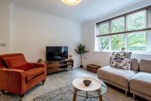 a living room with a couch and a tv at Ascot Racecourse Apartment in Ascot