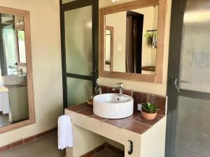 a bathroom with two sinks and two mirrors at Honey Badger Lodge in Moshi +31 photos