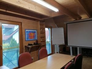 a conference room with a table and a projection screen at Ferienhaus Nebenan Plus in Ebern