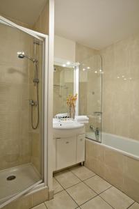 a bathroom with a sink and a shower and a tub at Residhome Arcachon Plazza in Arcachon