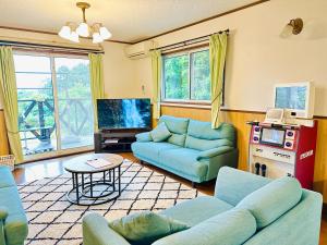 a living room with blue couches and a tv at ラシェール 伊豆 ガーデンテラス AWA Resort in Ito