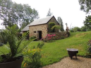 a garden with a stone building on a hill at Chambre d'hôte Monthorin in Vernie