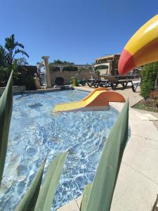 a swimming pool with a slide and a playground at Camping les Acacias in Fréjus