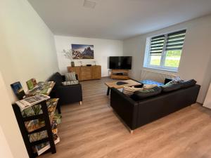 a living room with two couches and a flat screen tv at Ferienhaus Hirschi in Eisenach