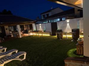 a backyard at night with a table and two trash cans at La Casita del Tejar in Cardiel de los Montes