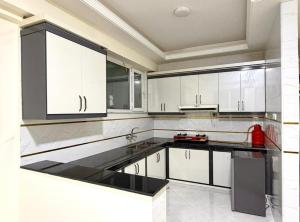 a kitchen with white cabinets and a red appliance at Gulbahar Residences in Kabul