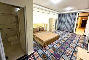 a hotel room with a bed and a bathroom at Gulbahar Residences in Kabul