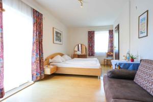 a hotel room with a bed and a couch at Strandhotel Pichler in Seeboden