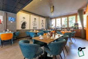 a dining room with tables and blue chairs at Hotiday Milano CityLife in Milan