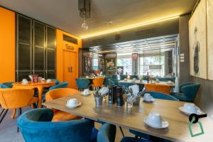 a restaurant with a wooden table and blue chairs at Hotiday Milano CityLife in Milan