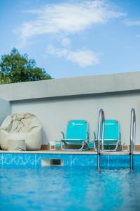 a pool at a resort with two chairs and a swimming pool at Nature Oasis Kravari - Private Pool & Jacuzzi in Stegvaši