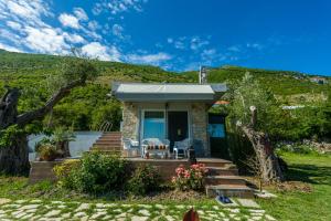 a house with a green hill in the background at Nature Oasis Kravari - Private Pool & Jacuzzi in Stegvaši