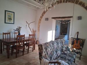 a living room with a couch and a table with a guitar at Agri Experience - Case Gentile in Castelvetrano Selinunte
