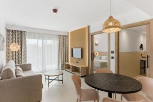a living room with a couch and a table at Aquasol Aparthotel in Palmanova