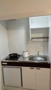 a small kitchen with a sink and a stove at Hotel Route35 Shiomi in Sasebo