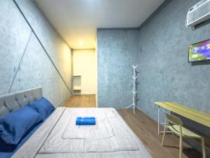 a room with a bed and a table and a tv at Kamar Pluit Karang in Jakarta
