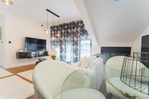 a living room with white furniture and a glass table at Liberty Central Apartment in Tuzla